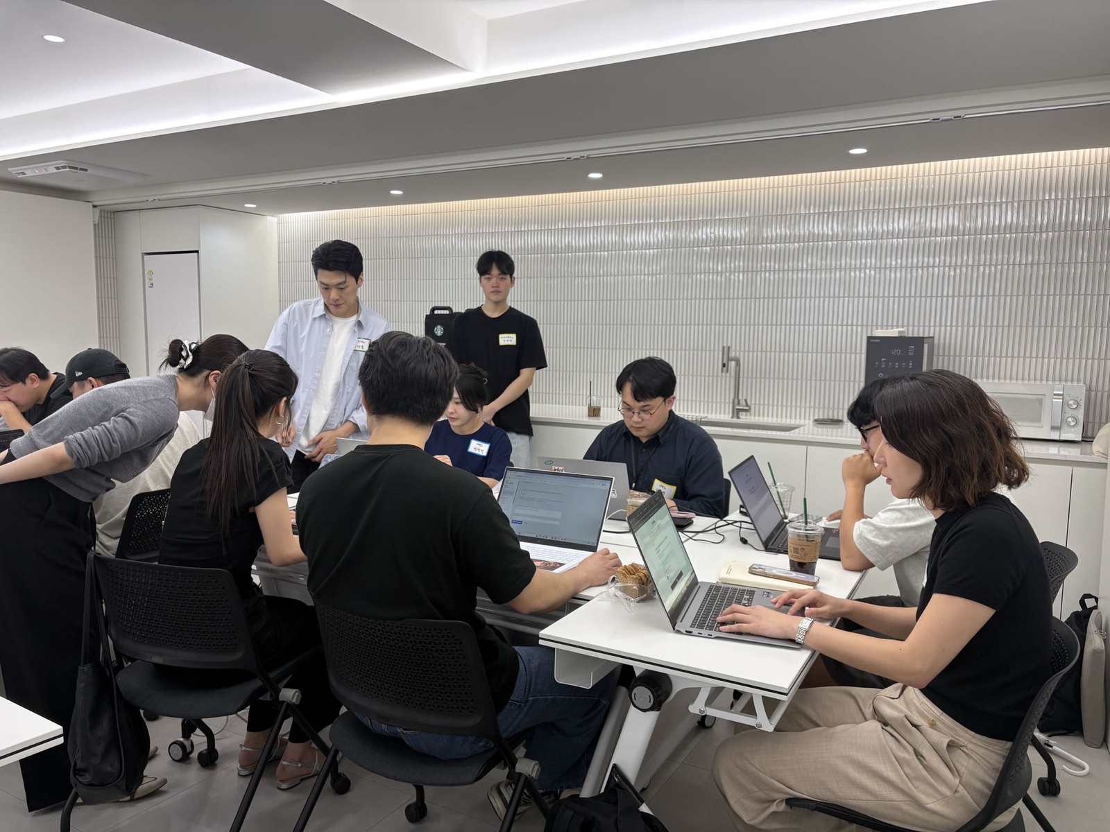 참가자들이 테이블에 모여 노트북으로 각자의 도구를 만드는 모습